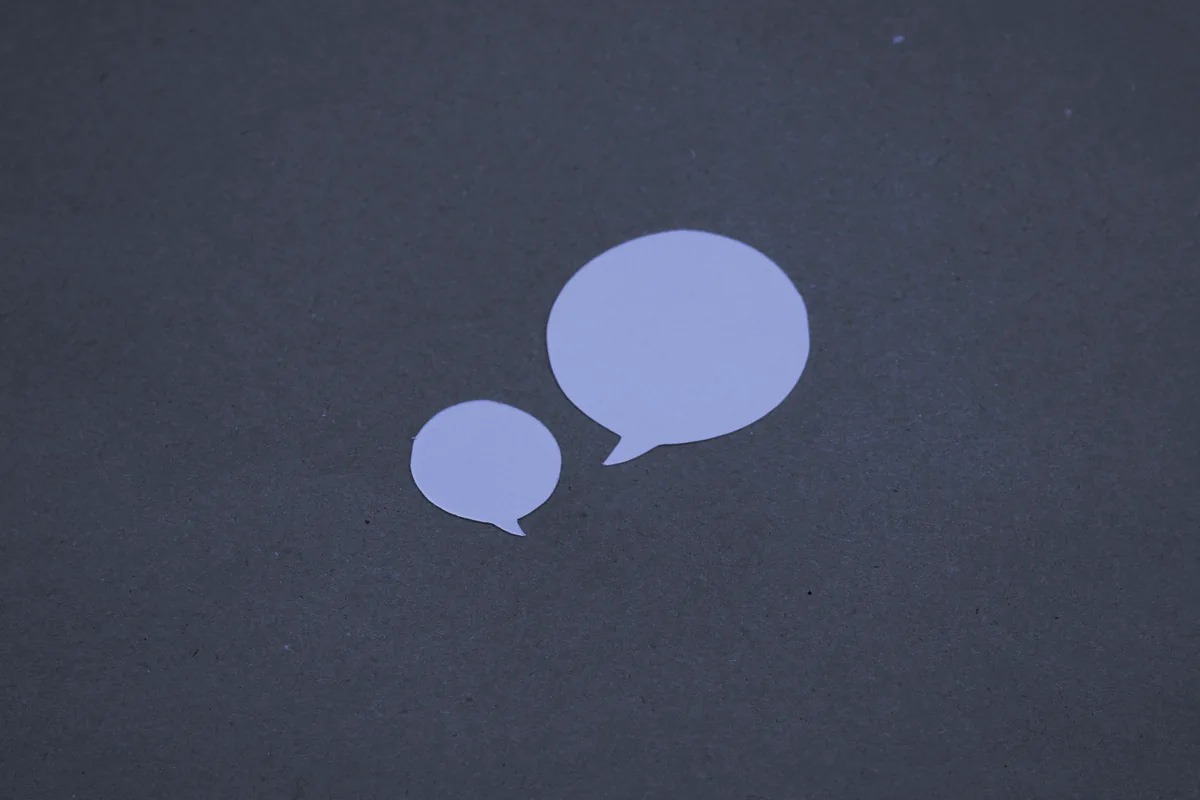 Dos bocadillos de conversación de papel sobre un fondo de cartón