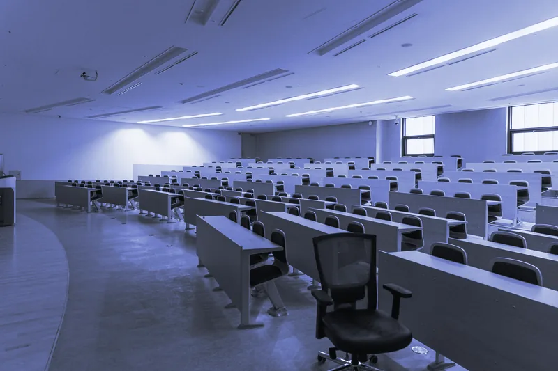 Aula con filas de pupitres de madera preparada para una formación