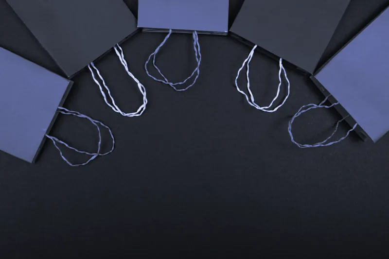 Bolsas de papel lisas con asas de cordón sobre un fondo oscuro
