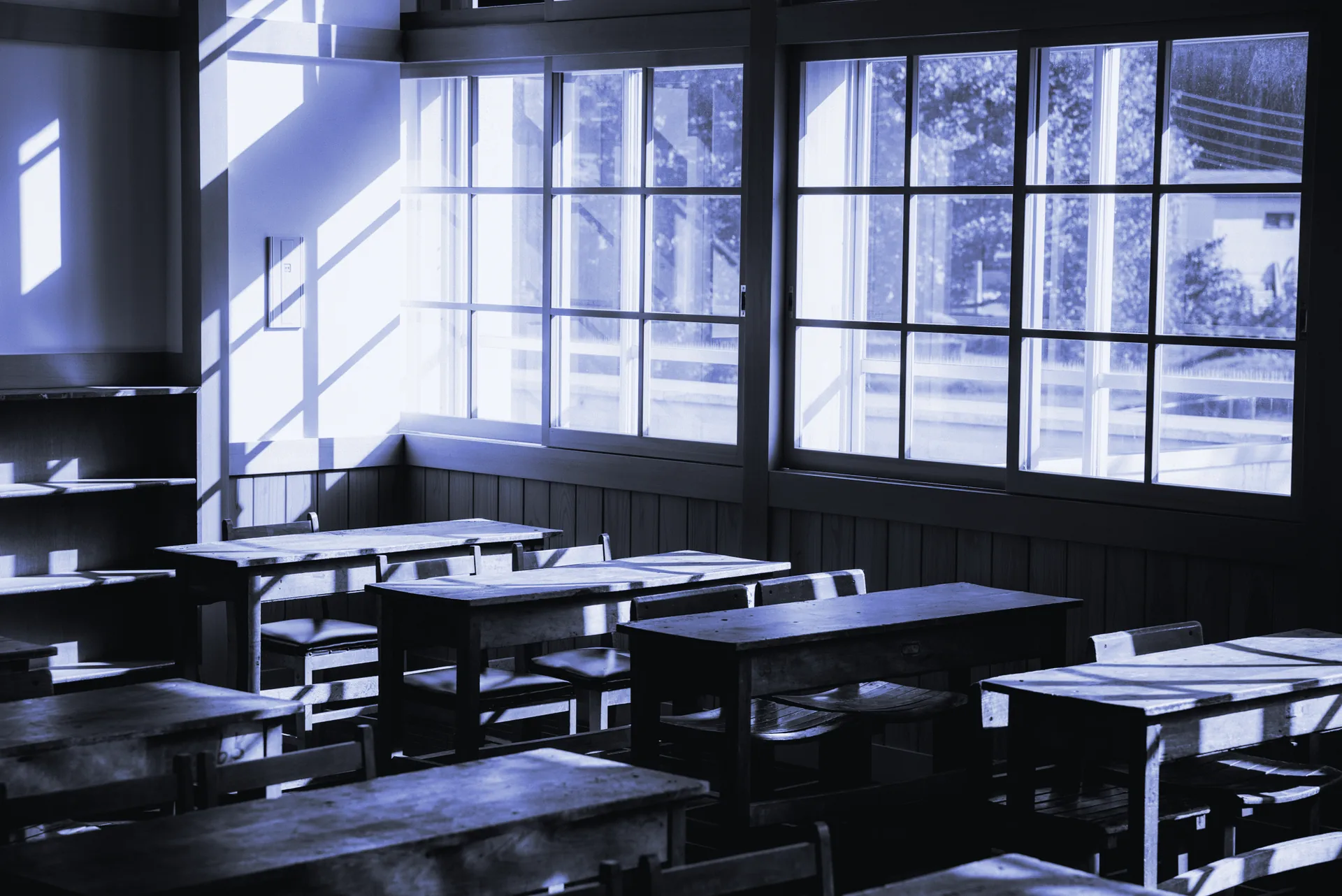 Aula con pupitres de madera iluminada por la luz de las ventanas