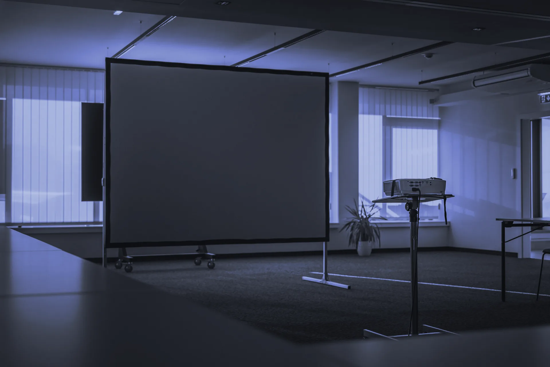 Sala de formación con la pantalla de proyección y el proyector preparados