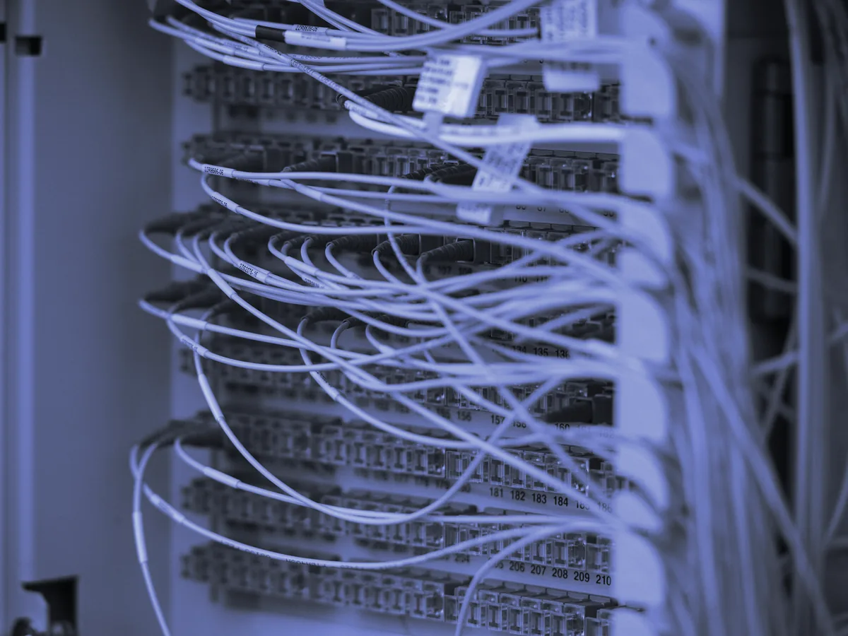 Cables de fibra óptica conectados a los puertos de un panel de comunicaciones