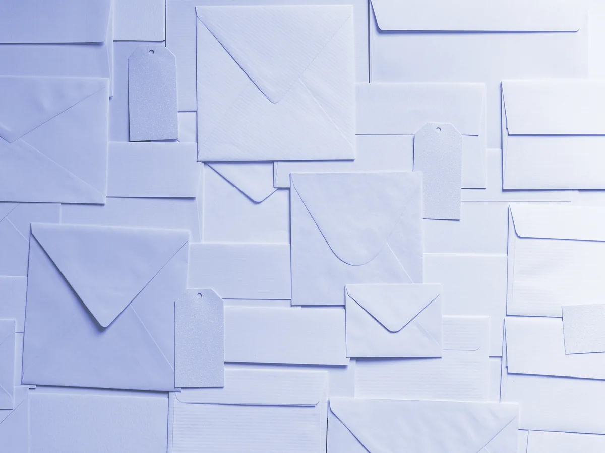Sobres y etiquetas de papel de distintos tamaños sobre una superficie blanca
