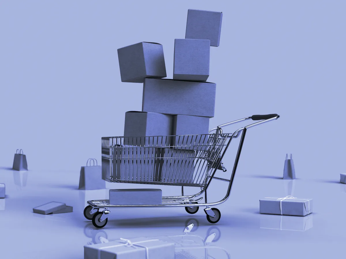 Carrito de la compra lleno de cajas de envío sobre un fondo azul