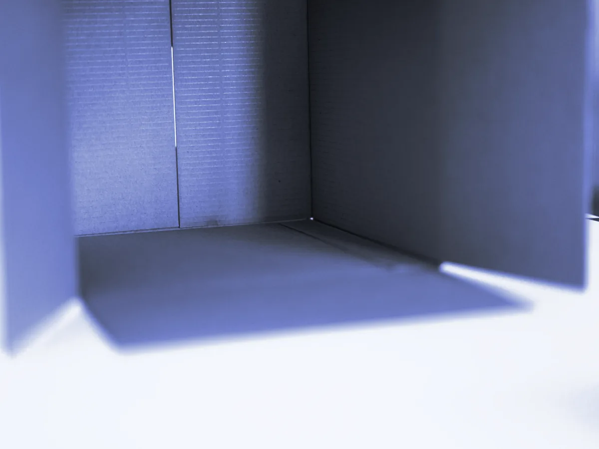 Caja de cartón abierta y vacía sobre una mesa blanca