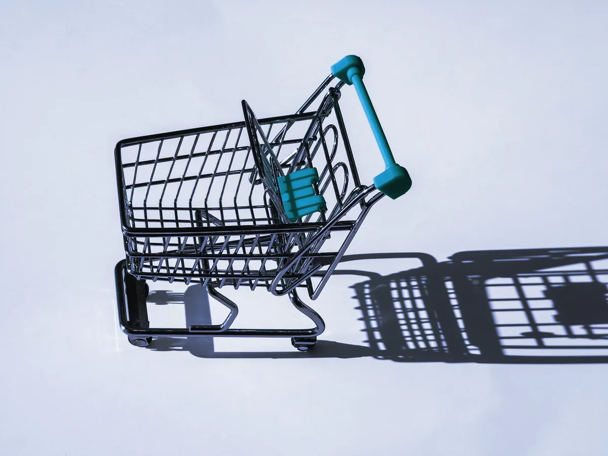 Carrito de la compra en miniatura sobre un fondo claro