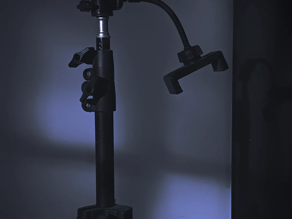 Trípode con soporte para el móvil junto a una pared