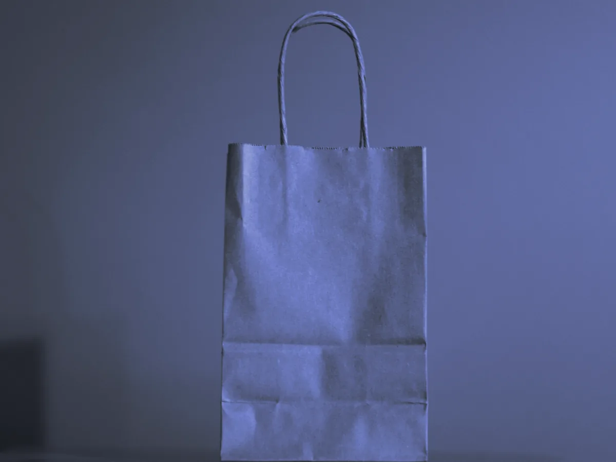 Bolsa de papel lisa con asas sobre una mesa