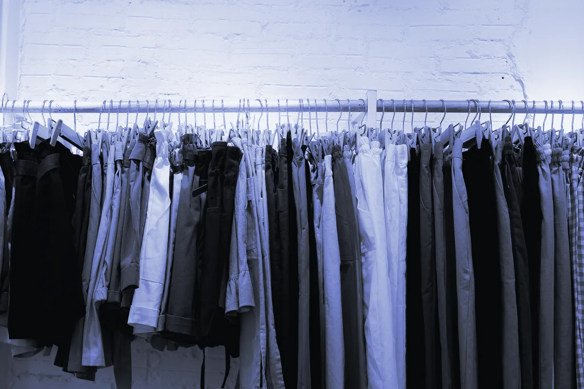 Ropa colgada en perchas de madera en la barra de una tienda